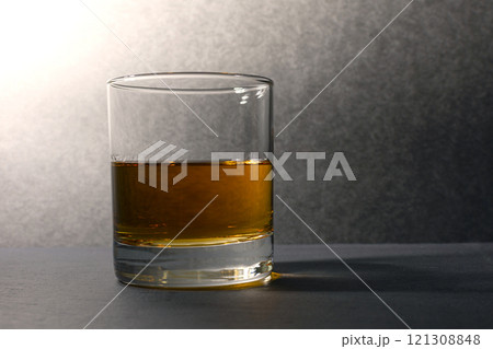 glass goblet with whiskey on a dark background 121308848