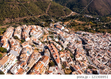 Ojen, small Spanish old town village of white Andalucian houses with green nature around on a sunny day 121308951