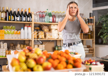 Female shopper suffers from headache while shopping at supermarket Female shopper suffers from headache while shopping at supermarket 121309172