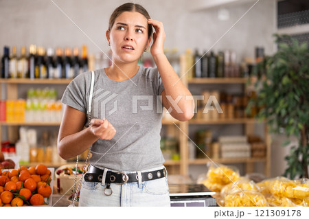 Thoughtful woman in a supermarket Thoughtful woman in a supermarket 121309178