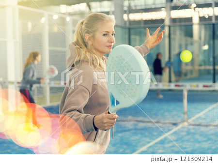 Woman playing padel in court Woman playing padel in court 121309214