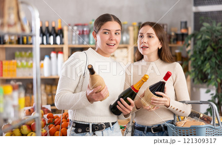 Two women choosing wine in a supermarket 121309317