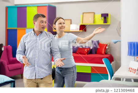 Couple choose and consider furniture in furniture store Couple choose and consider furniture in furniture store 121309468