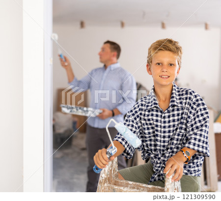 Portrait of positive young boy with paint roller 121309590