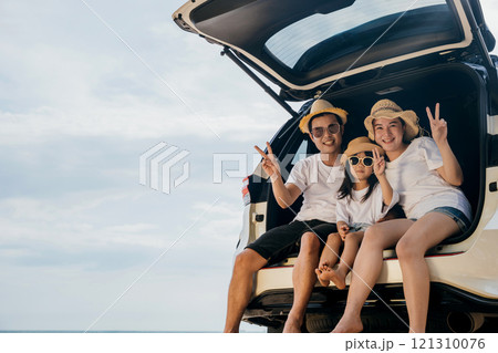 Family Day. Happy people having fun in summer vacation on beach, Family traveling in holiday at sea beach, Dad, mom and children daughter enjoying road trip sitting on back car showing V-sign signal Family Day. Happy people having fun in summer vacation on beach, Family traveling in holiday at sea beach, Dad, mom and children daughter enjoying road trip sitting on back car showing V-sign signal 121310076