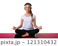 Young woman with headset sitting in meditating pose of lotus on yoga mat, isolation white background 121310432