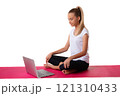 Sporty young smiling woman sitting in pink yoga mat and using laptop, isolated on white background 121310433