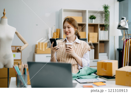 Young business owner woman prepare parcel box and standing check online orders for deliver Young business owner woman prepare parcel box and standing check online orders for deliver 121310913
