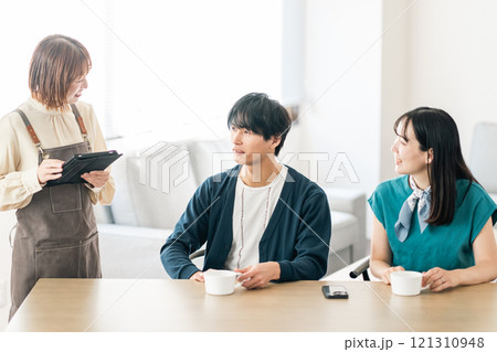 おしゃれなカフェでオーダーを取るスタッフとカップル 121310948