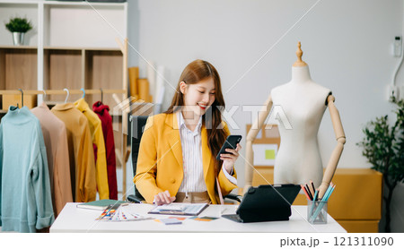 Asian tailor woman working on clothes in tailoring atelier. beautiful young female fashion designer smile 121311090