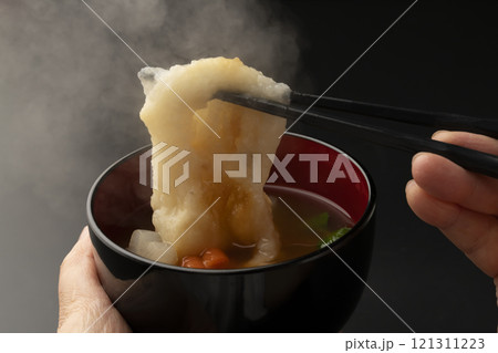 お雑煮のお椀を手で持ち餅を箸で持ち上げる お雑煮のお椀を手で持ち餅を箸で持ち上げる 121311223