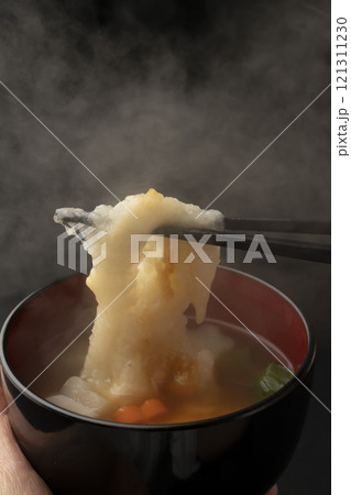 お雑煮のお椀を手で持ち餅を箸で持ち上げる お雑煮のお椀を手で持ち餅を箸で持ち上げる 121311230
