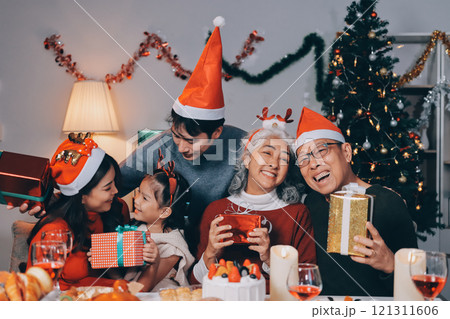 Happy family with gifts celebrating Christmas together Happy family with gifts celebrating Christmas together 121311606