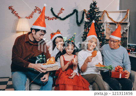 Portrait of Asian family exchanging presents during christmas at home. Attractive happy people holding gift box, celebrate holiday thanksgiving, xmas eve tradition in living room in house together. Portrait of Asian family exchanging presents during christmas at home. Attractive happy people holding gift box, celebrate holiday thanksgiving, xmas eve tradition in living room in house together. 121311656