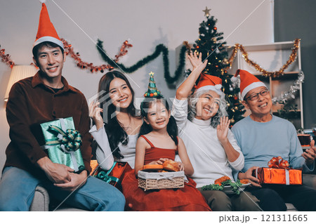 Portrait of Asian family exchanging presents during christmas at home. Attractive happy people holding gift box, celebrate holiday thanksgiving, xmas eve tradition in living room in house together. Portrait of Asian family exchanging presents during christmas at home. Attractive happy people holding gift box, celebrate holiday thanksgiving, xmas eve tradition in living room in house together. 121311665