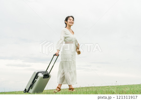 スーツケースを持って旅行に来た若いアジア人女性(夏・リゾート・バカンス) スーツケースを持って旅行に来た若いアジア人女性(夏・リゾート・バカンス) 121311917