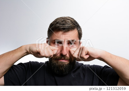 Man with beard rubbing his eyes 121312059