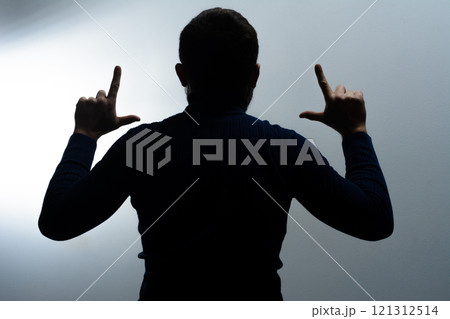 Silhouette of person gesturing with hands raised 121312514