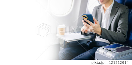Young Asian executive excels in first class, multitasking with digital tablet, laptop and smartphone. Young Asian executive excels in first class, multitasking with digital tablet, laptop and smartphone. 121312914