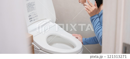 トイレのトラブルで水道業者に電話する女性 121313271