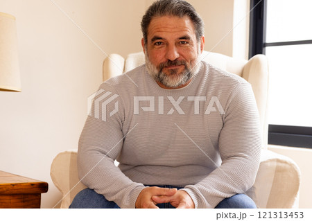 Smiling mature man sitting comfortably at home, enjoying peaceful moment 121313453