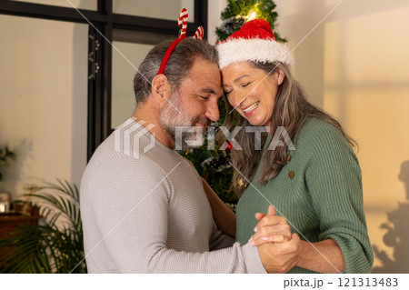 Dancing joyfully at home, mature couple celebrating Christmas together 121313483