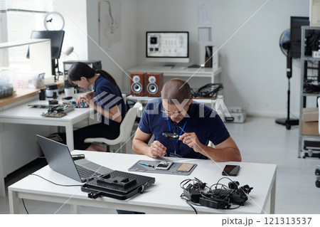 Two technicians focusing on electronics repair...の写真素材 [121313537] - PIXTA