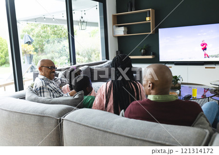 Excited african american parents, son, daughter and grandparents watching rugby on tv, slow motion 121314172