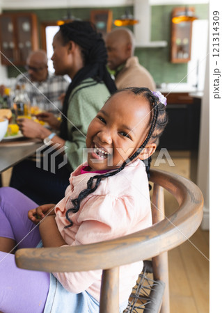 Portrait of african american daughter laughing at thanksgiving dinner table 121314309
