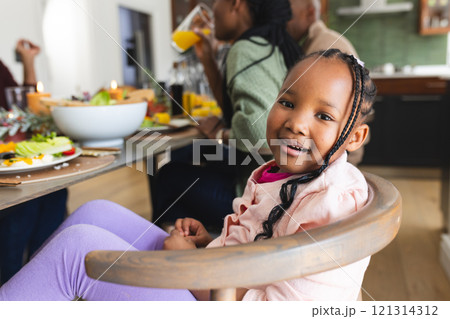 Portrait of african american daughter smiling at thanksgiving dinner table 121314312