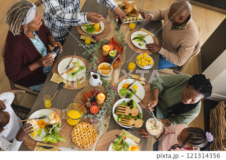 African american parents, children and grandparents celebrating at thanksgiving dinner 121314356
