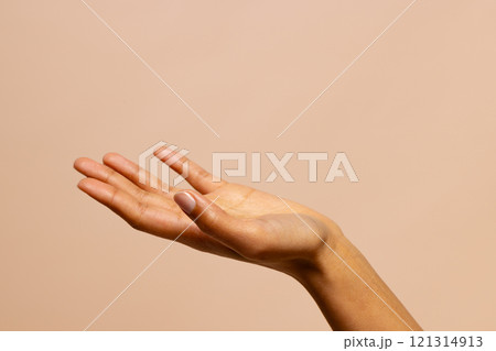 Outstretched hand of biracial woman on pink beige background with copy space 121314913