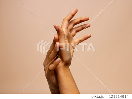 Touching hands of biracial woman on pink beige background with copy space 121314914
