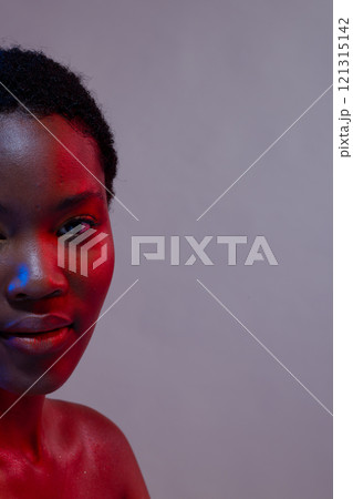 Half portrait of african american woman with short hair in blue and red light, copy space 121315142
