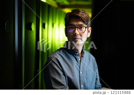 Asian male engineer using laptop in computer server room 121315988