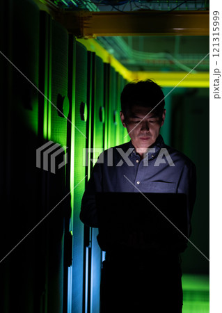 Asian male engineer using laptop in computer server room Asian male engineer using laptop in computer server room 121315999