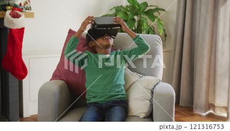 Happy african american boy wearing vr headset and having fun at christmas time Happy african american boy wearing vr headset and having fun at christmas time 121316753