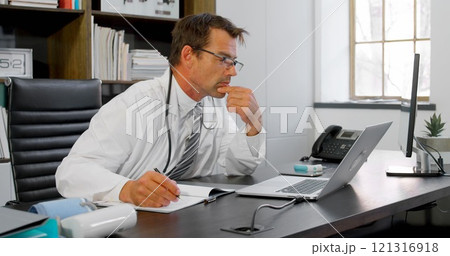 Physician looking at laptop on his desk in clinic 4k 121316918