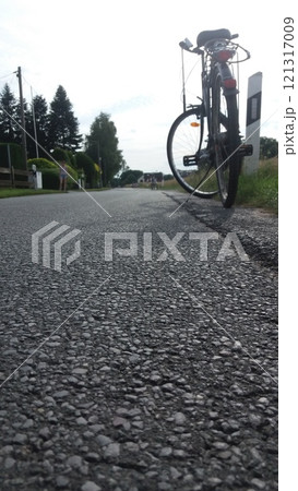 A Bicycle Riding on a Gravel Road Surrounded by an Exquisite and Beautiful Scenic Landscape 121317009