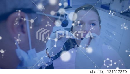 Image of molecules over caucasian male dentist and female patient Image of molecules over caucasian male dentist and female patient 121317270