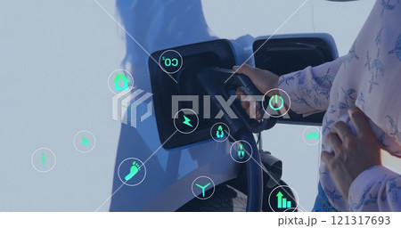 Image of eco icons over african american man charging electric car Image of eco icons over african american man charging electric car 121317693