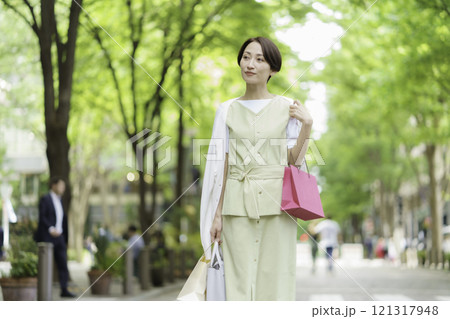 新緑の中ショッピングをするミドルエイジの女性 121317948