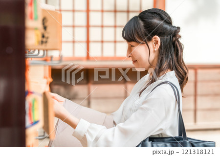 神社で絵馬を奉納するアジア人女性 121318121