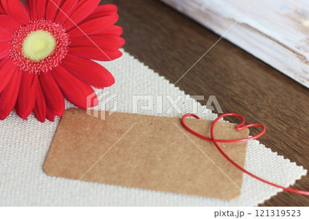 赤いガーベラと茶色のメッセージカード　赤いハートのワイヤー 121319523