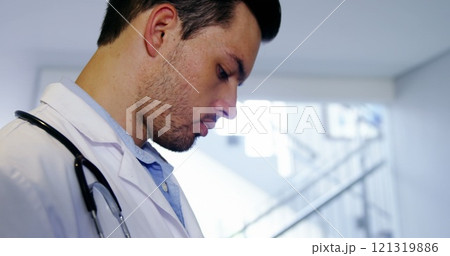 Doctor using digital tablet in corridor at hospital 121319886