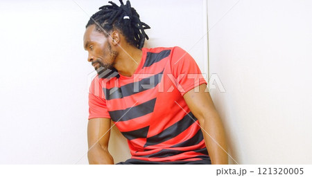 Frustrated athlete sitting alone in the locker room Frustrated athlete sitting alone in the locker room 121320005