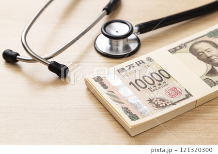 机に置かれた聴診器と100万円 机に置かれた聴診器と100万円 121320300