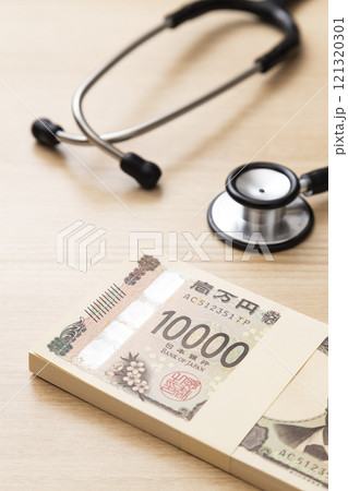 机に置かれた聴診器と100万円 机に置かれた聴診器と100万円 121320301