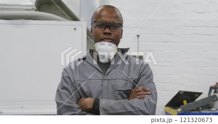 Portrait of an African American male car mechanic working in a township workshop, crossing his arms Portrait of an African American male car mechanic working in a township workshop, crossing his arms 121320673