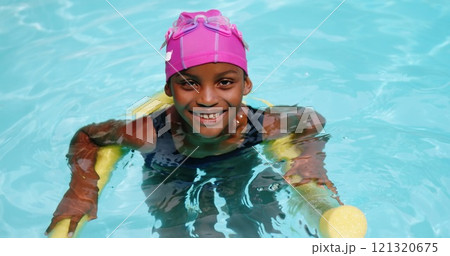 Portrait of young girl swimming with inflatable tube in the pool 121320675